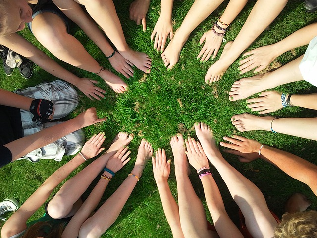 People hands & feet together in the grass (land) 