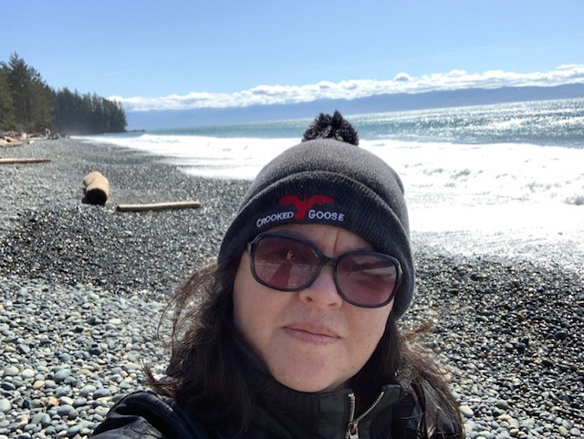 middle aged woman with sunglasses and a toque at the beach