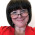 Headshot of Kate Jennings. Kate is wearing a red sweater, large silver pendant, and reading glasses.